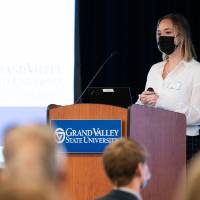 Scholar wearing mask presenting research with oral presentation.